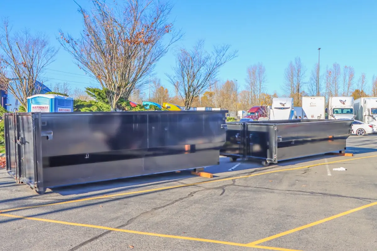 Professional dumpster rental service with roll-off container on residential driveway in Pine Hill